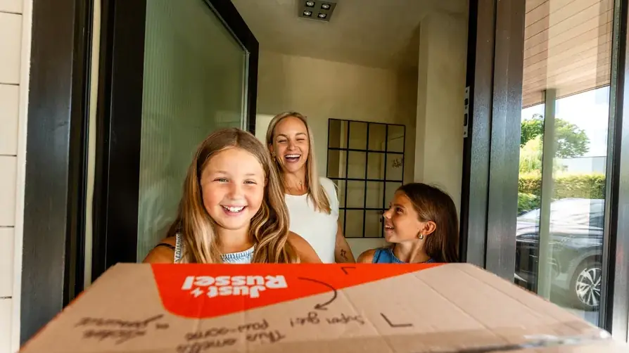 Famille recevant son carton de croquettes Just Russel à la porte
